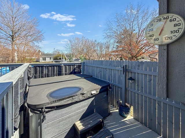 wooden terrace featuring fence and a hot tub