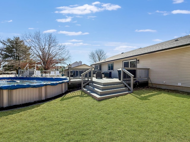 back of house with a covered pool, a lawn, and a wooden deck