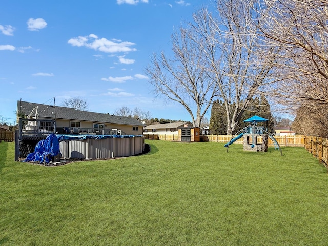 view of yard with a fenced backyard, a playground, and a covered pool