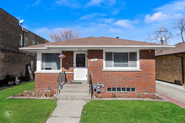 bungalow-style home featuring brick siding, roof with shingles, and a front yard