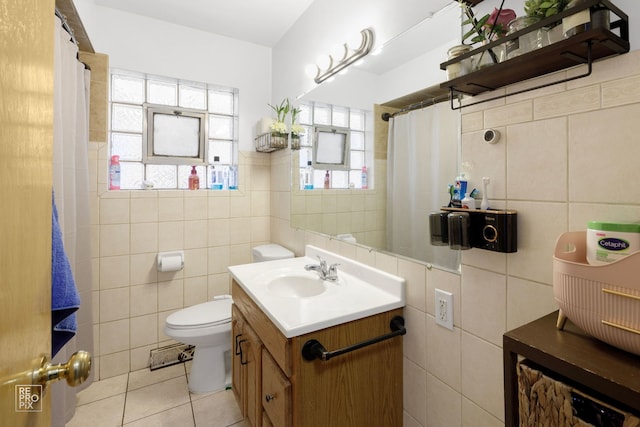 full bath with toilet, vanity, tile walls, and tile patterned floors