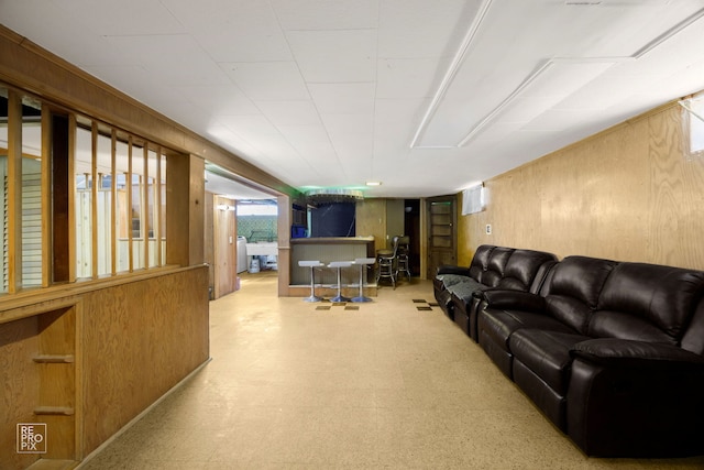 living area with wooden walls and tile patterned floors