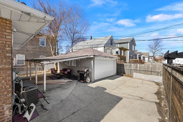 exterior space featuring central AC, an outdoor structure, fence, a detached garage, and a residential view