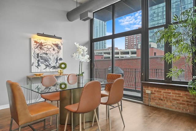 dining space with a wall of windows, baseboards, and wood finished floors