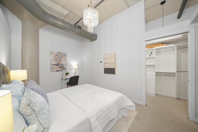 carpeted bedroom with baseboards, a chandelier, and a closet