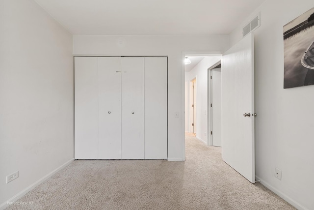 unfurnished bedroom with a closet, carpet flooring, visible vents, and baseboards