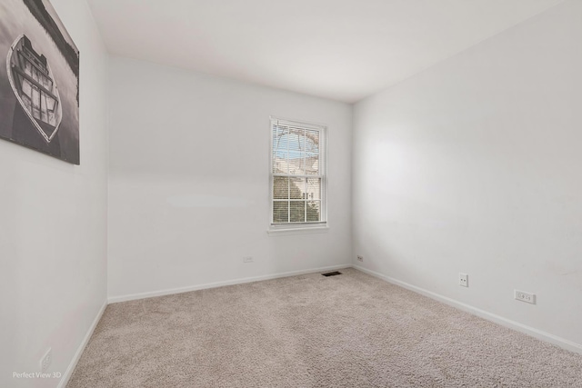 spare room with baseboards, visible vents, and carpet flooring