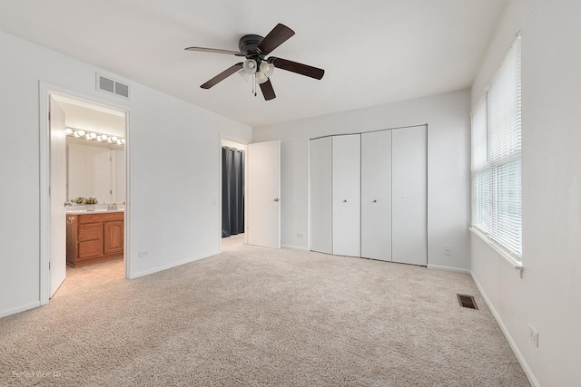 unfurnished bedroom featuring visible vents, light carpet, and baseboards