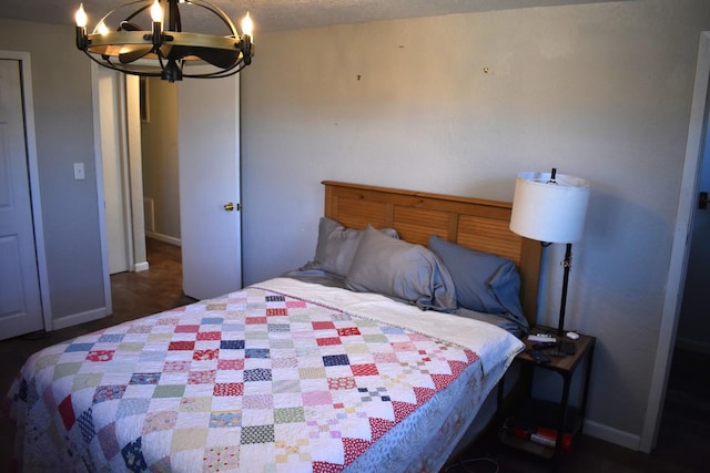 bedroom with baseboards and a chandelier