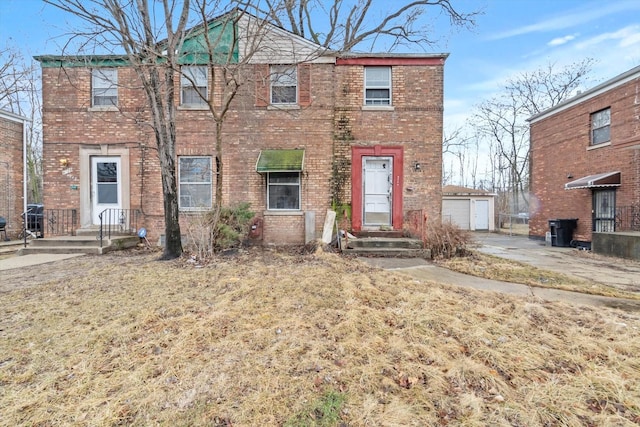 view of front of home with an outdoor structure and brick siding