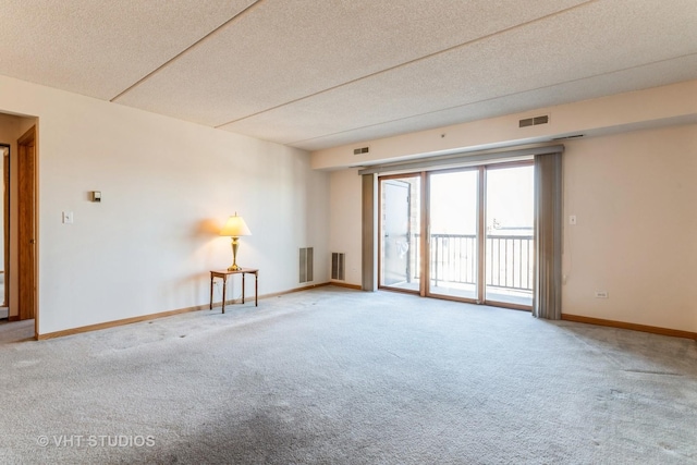 spare room featuring visible vents, carpet flooring, and baseboards