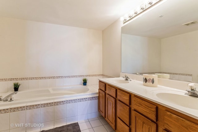 bathroom with tile patterned flooring, a garden tub, visible vents, and a sink