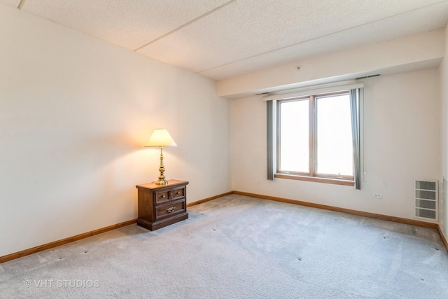 carpeted empty room featuring visible vents and baseboards