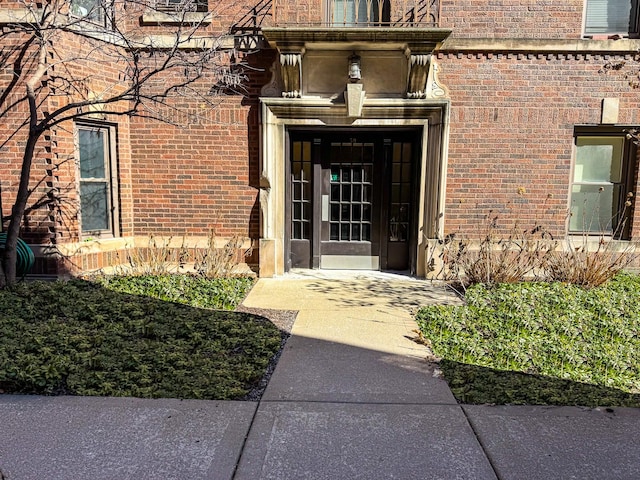 doorway to property featuring brick siding