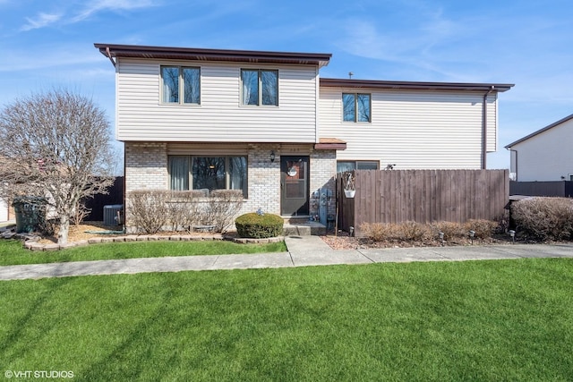 view of front of home with brick siding, central air condition unit, a front yard, and fence