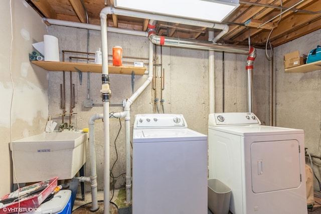 washroom with a sink, laundry area, and washing machine and clothes dryer