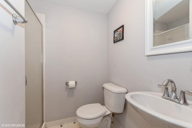 full bathroom with an enclosed shower, toilet, baseboards, and a sink