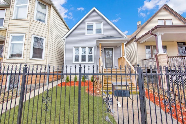 bungalow with a fenced front yard, a gate, and a front lawn