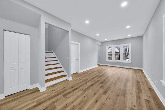 interior space featuring baseboards, stairway, wood finished floors, and recessed lighting