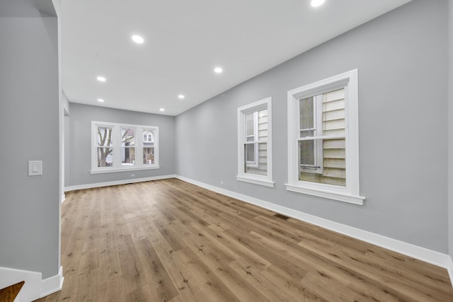 unfurnished living room with baseboards, visible vents, wood finished floors, and recessed lighting