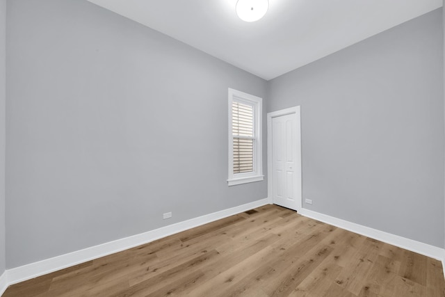 unfurnished room with baseboards and wood finished floors