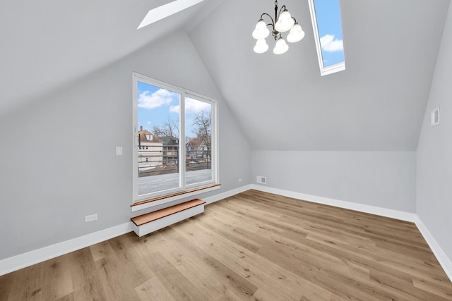 bonus room with vaulted ceiling with skylight, wood finished floors, visible vents, and baseboards