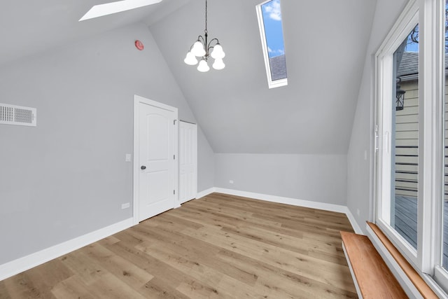 bonus room with vaulted ceiling with skylight, light wood-style flooring, visible vents, and baseboards