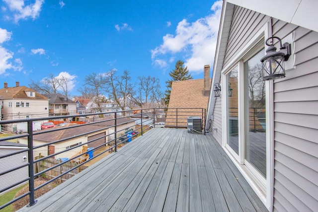 wooden deck featuring central air condition unit and a residential view