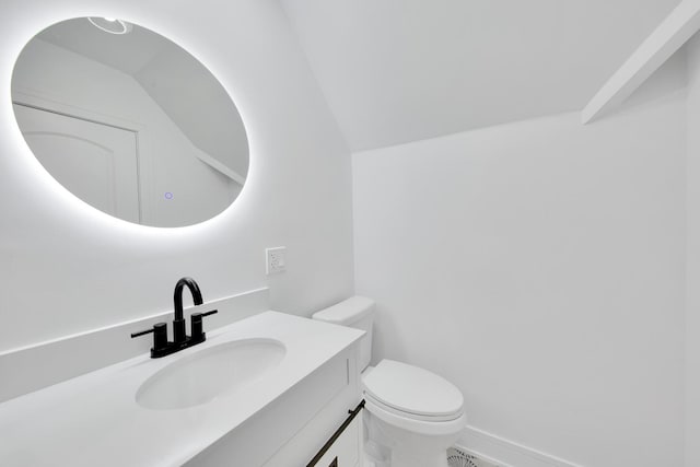 bathroom with vaulted ceiling, vanity, toilet, and baseboards