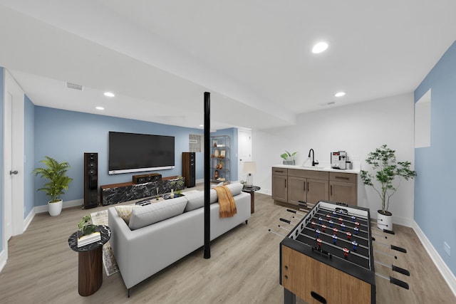 living area with light wood-style floors, baseboards, visible vents, and recessed lighting