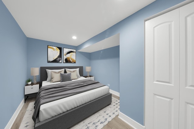 bedroom with light wood finished floors and baseboards