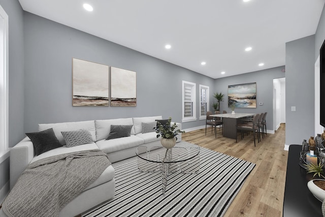 living room featuring light wood-style floors, baseboards, and recessed lighting