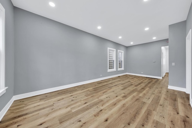 empty room featuring baseboards, wood finished floors, and recessed lighting