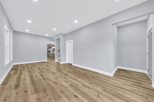 unfurnished living room with recessed lighting, stairway, baseboards, and light wood finished floors