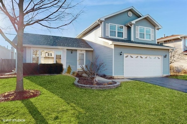 traditional-style home with aphalt driveway, an attached garage, fence, and a front lawn