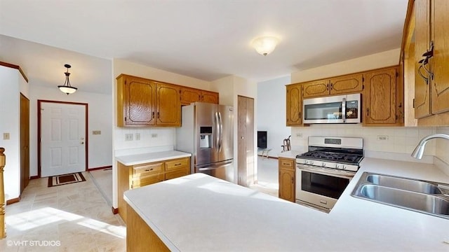 kitchen featuring a sink, decorative backsplash, appliances with stainless steel finishes, and light countertops