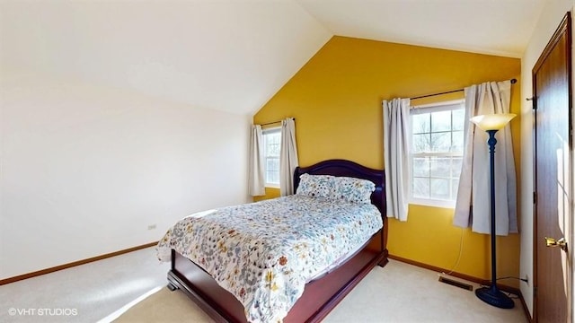 bedroom featuring multiple windows, light colored carpet, and lofted ceiling