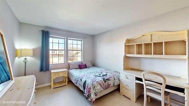 bedroom featuring light colored carpet and baseboards