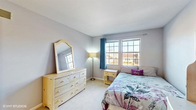 bedroom with light carpet, visible vents, and baseboards