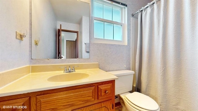 bathroom featuring a shower with curtain, toilet, and vanity