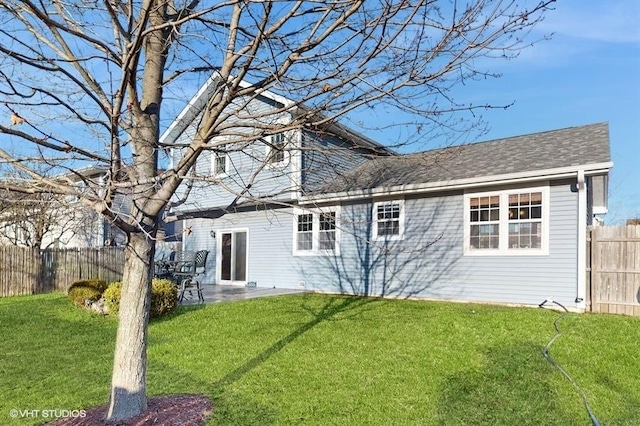 rear view of house with a patio area, a lawn, and fence