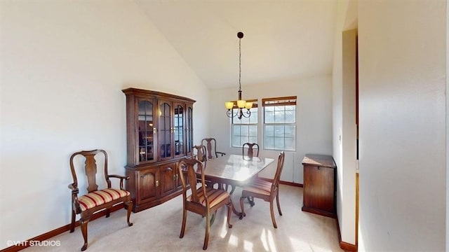 dining space with a notable chandelier, light colored carpet, baseboards, and high vaulted ceiling