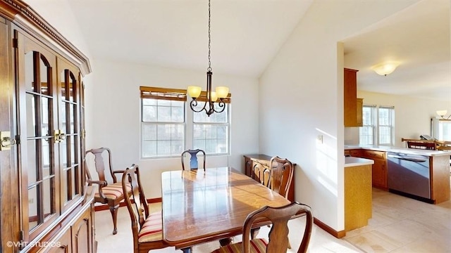 dining room with an inviting chandelier, baseboards, and lofted ceiling