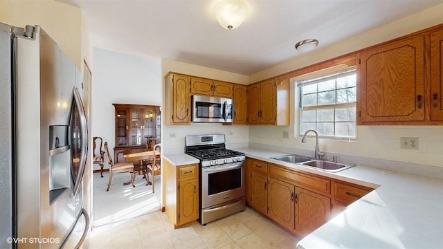 kitchen featuring a sink, light countertops, brown cabinets, and stainless steel appliances