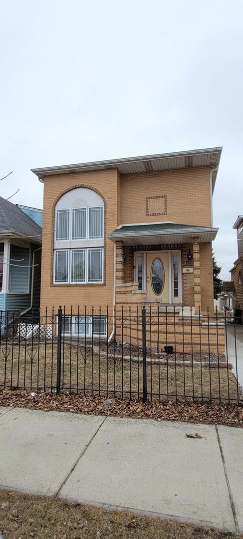 view of front of property featuring brick siding and a fenced front yard