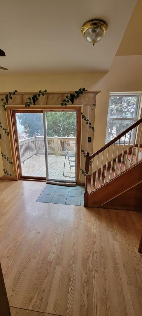 entryway featuring stairway, wood finished floors, and a wealth of natural light