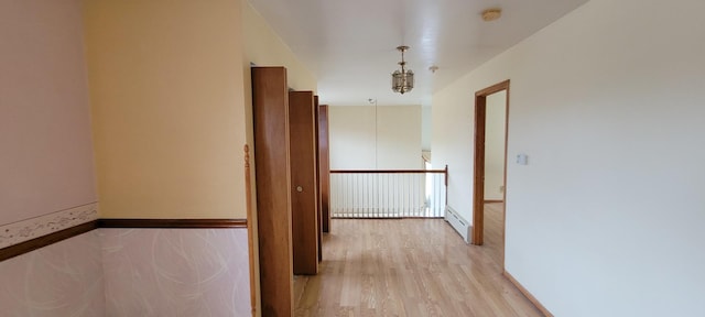 hallway featuring a baseboard heating unit and light wood-style floors