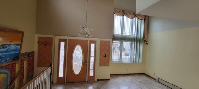 foyer featuring a baseboard radiator, baseboards, a high ceiling, and a chandelier