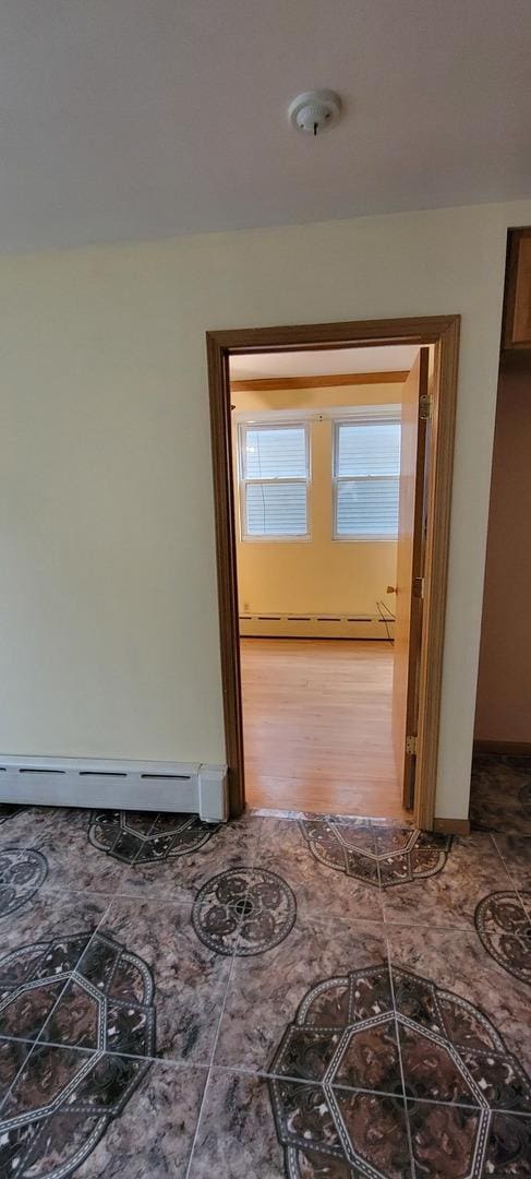 hallway featuring baseboards and a baseboard radiator