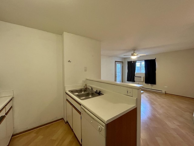 kitchen featuring light countertops, baseboard heating, a sink, light wood-type flooring, and a peninsula